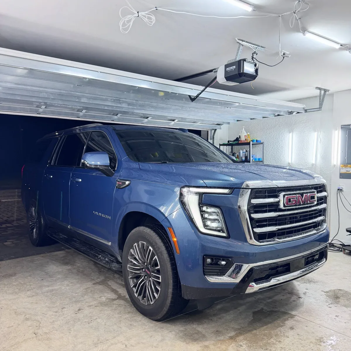 Blue GMC Yukon tinted inside the shop